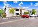 Well-maintained condo exterior featuring reserved parking spaces, manicured landscaping, and modern white facade at 120 S Church Ave # 202, Tampa, FL 33609