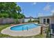 Backyard swimming pool is surrounded by green plants and a wooden fence at 12372 113Th St, Largo, FL 33778