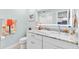 Well-lit bathroom vanity features granite countertops, decorative mirror, and adjacent toilet at 12525 3Rd E St # 303, Treasure Island, FL 33706