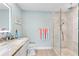 Bright bathroom features glass-enclosed shower, vanity with granite countertop, and updated fixtures at 12525 3Rd E St # 303, Treasure Island, FL 33706