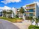 Stylish condo exterior featuring lush landscaping, a well-manicured lawn, and covered parking at 12525 3Rd E St # 303, Treasure Island, FL 33706