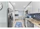Well-lit kitchen features white cabinetry, stainless steel appliances, and updated finishes at 12525 3Rd E St # 303, Treasure Island, FL 33706