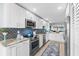 Bright kitchen boasts white cabinets, stainless steel appliances, and a blue backsplash at 12525 3Rd E St # 303, Treasure Island, FL 33706