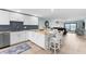 Open-concept kitchen featuring modern white cabinetry, stainless steel appliances, and a breakfast bar at 12525 3Rd E St # 303, Treasure Island, FL 33706