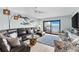 Spacious living room with a leather sectional, unique decor, and sliding doors to a waterfront balcony at 12525 3Rd E St # 303, Treasure Island, FL 33706