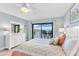 Inviting bedroom features balcony access with lovely water views and a decorative ceiling fan at 12525 3Rd E St # 303, Treasure Island, FL 33706