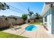 Secluded backyard featuring a sparkling pool, lounge chairs, and a manicured lawn at 1281 Robin Hood Ln, Dunedin, FL 34698