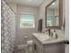 Bathroom featuring modern vanity with granite countertop, framed mirror, and shower with decorative curtain at 1281 Robin Hood Ln, Dunedin, FL 34698