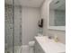 Bathroom features gray vanity, unique shower tile, modern fixtures, and a patterned shower curtain at 1281 Robin Hood Ln, Dunedin, FL 34698