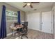 Bright bedroom featuring wood-look flooring, ceiling fan, and a work desk with window views at 1281 Robin Hood Ln, Dunedin, FL 34698