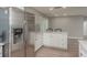 Open kitchen with stainless steel appliances, white cabinets, and breakfast bar seating at 1281 Robin Hood Ln, Dunedin, FL 34698