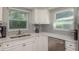 Close-up of the kitchen sink with stainless steel appliances and quartz countertops at 1281 Robin Hood Ln, Dunedin, FL 34698