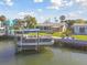 Waterfront property with a boat lift and a pontoon boat on a canal, showcasing outdoor living at 13323 Susan Dr, Hudson, FL 34667