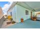 Exterior angle view of the house, with an outdoor seating area and view of the front yard at 13929 Muriel Ave, Hudson, FL 34667