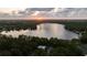 Beautiful lake view at sunset, showcasing homes nestled among trees with serene waterfront scenery at 14449 Wadsworth Dr, Odessa, FL 33556