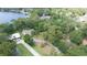 Aerial view of a property with a long driveway and mature trees near a lake at 14449 Wadsworth Dr, Odessa, FL 33556