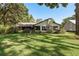 Well-maintained backyard with a lush lawn, mature trees, and a glimpse of the home's exterior at 14449 Wadsworth Dr, Odessa, FL 33556