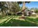 Grassy backyard with mature trees surrounding the house and providing natural shade at 14449 Wadsworth Dr, Odessa, FL 33556
