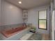 Bathroom featuring a built-in tub with tile surround and window at 14449 Wadsworth Dr, Odessa, FL 33556