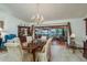 Elegant dining room with chandelier, wood table, chairs, and sliding doors to screened porch at 14449 Wadsworth Dr, Odessa, FL 33556