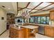 Bright kitchen featuring a central island, stainless steel appliances, and view into brick fireplace living area at 14449 Wadsworth Dr, Odessa, FL 33556