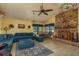 Bright and spacious living area with blue sofa, brick fireplace, ceiling fan, and large windows at 14449 Wadsworth Dr, Odessa, FL 33556