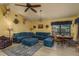Open living room featuring a ceiling fan, brick fireplace, blue sofa, and table setting at 14449 Wadsworth Dr, Odessa, FL 33556