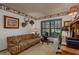 Cozy home office with a striped sofa, and a large window overlooking the trees at 14449 Wadsworth Dr, Odessa, FL 33556