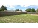 Large backyard with lush green grass and a wood fence, offering privacy and space at 1602 Taylor Lake Cir, Largo, FL 33778