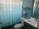 Cozy bathroom featuring a toilet, vanity, mirror, and tub with blue curtain at 1602 Taylor Lake Cir, Largo, FL 33778