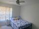 Bright bedroom featuring a ceiling fan, window, and bed with nautical-themed bedding at 1602 Taylor Lake Cir, Largo, FL 33778
