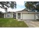 Charming single-story home with a well-manicured lawn and an attached two-car garage at 1602 Taylor Lake Cir, Largo, FL 33778