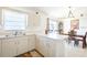 Bright kitchen featuring white cabinets, stainless steel sink, and an adjacent dining area at 1602 Taylor Lake Cir, Largo, FL 33778