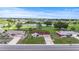 Aerial view of neighborhood with houses and a lake; central house has a red roof, and nearby homes have grey roofs at 1609 Pebble Beach N Blvd, Sun City Center, FL 33573
