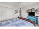 Cozy bedroom featuring a ceiling fan, wall decorations, a flat-screen TV, and a comforting blue and white quilt at 1609 Pebble Beach N Blvd, Sun City Center, FL 33573
