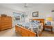 Comfortable bedroom with a ceiling fan, natural light from the window, and warm-colored wooden furniture at 1609 Pebble Beach N Blvd, Sun City Center, FL 33573