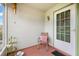 Cozy front porch featuring a chair, pillows, wind chimes, and front door at 1609 Pebble Beach N Blvd, Sun City Center, FL 33573