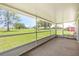 Interior view of a screened-in porch with seating, providing an unobstructed view of the green lawn at 1609 Pebble Beach N Blvd, Sun City Center, FL 33573
