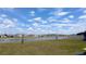 Scenic backyard view featuring a peaceful lake and a row of well-maintained homes, with sky and clouds at 16728 Kingman Reef St, Wimauma, FL 33598
