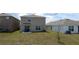 A backyard with a view of the home's exterior, landscaping and a tree at 16728 Kingman Reef St, Wimauma, FL 33598
