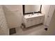 This bathroom has a dual sink vanity with modern fixtures, clean white cabinets, and neutral decor at 16728 Kingman Reef St, Wimauma, FL 33598