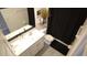 Bright bathroom featuring dual sinks, a toilet, and a shower with a stylish black curtain at 16728 Kingman Reef St, Wimauma, FL 33598