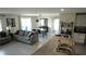 Open-concept living space featuring a kitchen island, dining area, and comfortable seating at 16728 Kingman Reef St, Wimauma, FL 33598