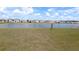 Expansive lawn leading to a tranquil pond, providing a serene view at 16728 Kingman Reef St, Wimauma, FL 33598
