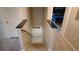 Open staircase leading downstairs, with carpeted steps and stylish railing, leading to a tiled floor at 16728 Kingman Reef St, Wimauma, FL 33598