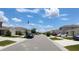Neighborhood street view showcasing modern homes with well-kept lawns and parked cars at 16728 Kingman Reef St, Wimauma, FL 33598