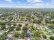 Wide aerial shot showcasing a residential area featuring mature trees, various homes, and a glimpse of water in the distance at 1675 Eden Ct, Clearwater, FL 33756
