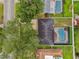 Aerial view of a house with a backyard pool, nice lawn, and mature trees at 1675 Eden Ct, Clearwater, FL 33756