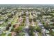 High-angle aerial view of a dense suburban area with tree-lined streets and houses with well-maintained yards at 1675 Eden Ct, Clearwater, FL 33756