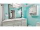 Bright bathroom with double vanity, large mirror, and storage for bath linens and other essentials at 1675 Eden Ct, Clearwater, FL 33756